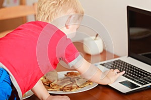 Little boy using laptop computer playing games