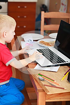 Little boy using laptop computer playing games