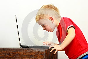 Little boy using laptop pc computer at home