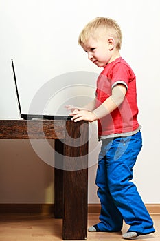 Little boy using laptop pc computer at home