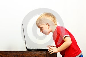 Little boy using laptop pc computer at home