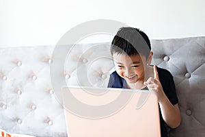 Little boy using laptop play game at home for relax
