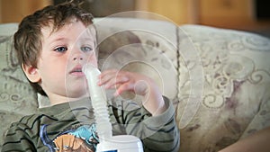 Little boy using nebulizer to inhale medicine, close up, stock footage