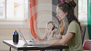 Little boy using touch pad when his mother working remotely