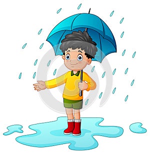 Little boy using umbrella under the rain