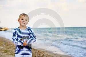 The little boy in the vest with binoculars