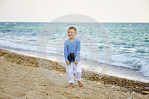 The little boy in the vest with binoculars