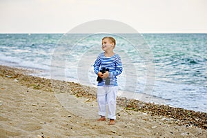 The little boy in the vest with binoculars