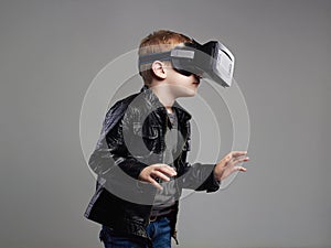 Little Boy in virtual reality glasses playing the game. kids fun