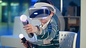 Little boy with virtual reality motion controllers having immersive gaming experience