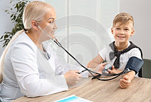 Little boy visiting doctor in hospital. Measuring blood pressure