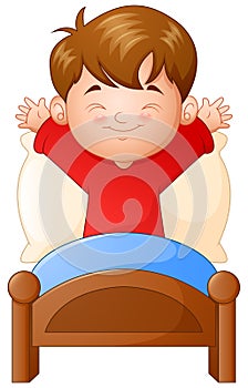 Little boy waking up in a bed on white background photo