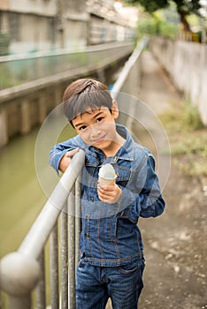 Little boy walking and eating ice cream