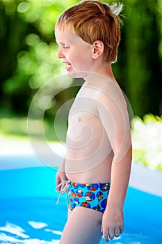 Little boy walking in a swimming pool