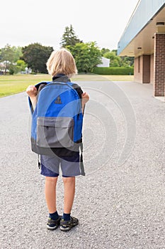 Little boy walking to school. Back to school concept. Child near school photo