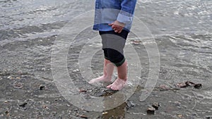 Little boy walks along the river. the child runs around the lake. slow motion. happy baby playing near the water. baby