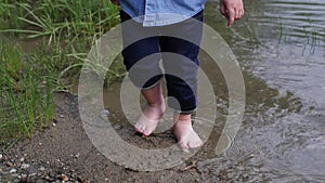 Little boy walks along the river. the child runs around the lake. slow motion. happy baby playing near the water. baby