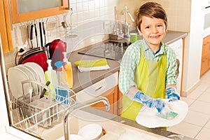 Little boy wash dished in sink with mop and soap