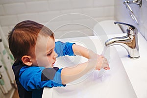 Little boy washing his hands