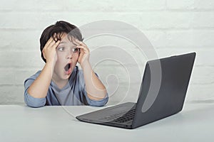 Little boy watching inappropriate content on laptop computer