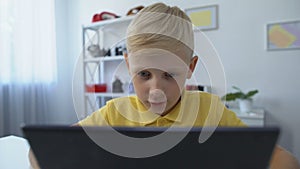 Little boy watching movie on tablet pc at home, modern technologies, application