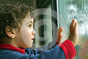 Little boy watching the rain