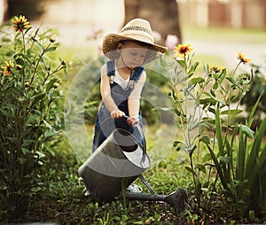 Little boy watering flowers