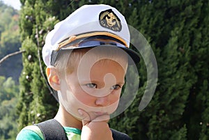 A little boy wearing a cap captain