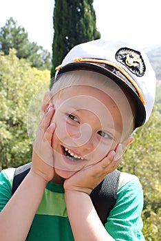 A little boy wearing a cap captain