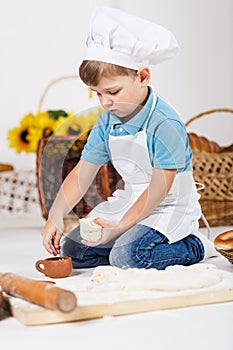 Little boy wearing chef hats baking a pie