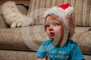 A little boy wearing harlequin hat watching TV, blur and grain effect. Funny children.