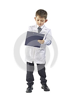 Little boy wearing lab coat making notes in clipboard on white background
