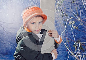 Little boy wearing warm clothes and orande hat outdoor