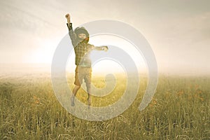 Little boy wears helmet during jumps in the meadow