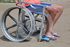 Little boy on the wheelchair on the beach