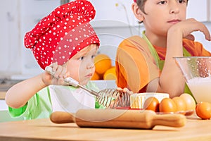 Little boy with whisk cook dough, cookies at home