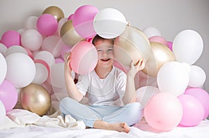 Little boy in white balloons . Small child with party balloons, celebration. Birthday, happiness, childhood, look