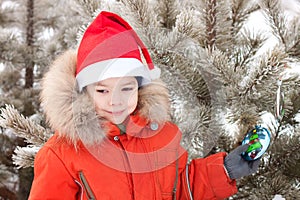 Little boy at the winter walk is decorated with