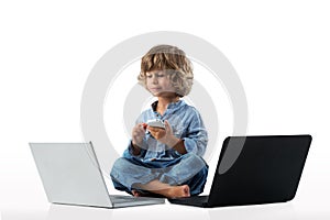 Little boy wiyh laptops and smartphone