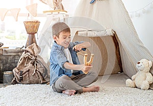 Little boy with wood slingshot