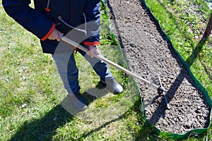 Little boy working in the garden. Work for kids outdoors