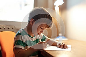 Little boy write to blank paper