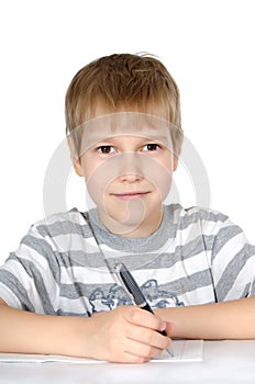 The little boy writes to writing-books a ball pen