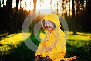 Little boy in a yellow jacket sits on a stump in the forest. Nature care concept.  . Action against deforestation. Take care of th