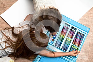 Little boys drawing a picture on the floor in his room, top view.