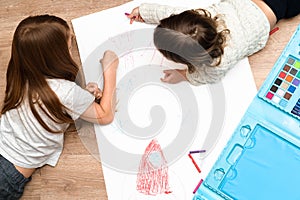 Little boys drawing a picture on the floor in his room, top view.
