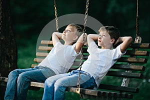 Little boys dreaming on swing