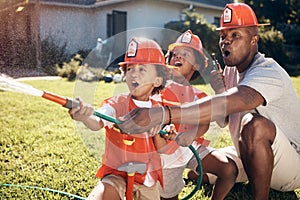 Little boys in firemen costumes. African American father playing with his children. Little boys playing in the garden