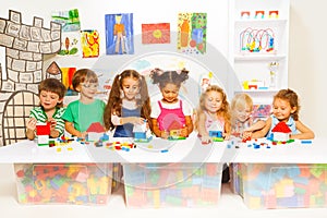 Little boys and girls constructing toy houses