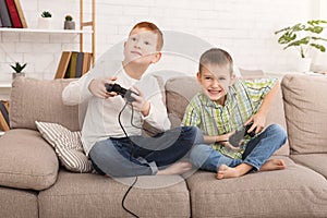 Little boys playing game console at home
